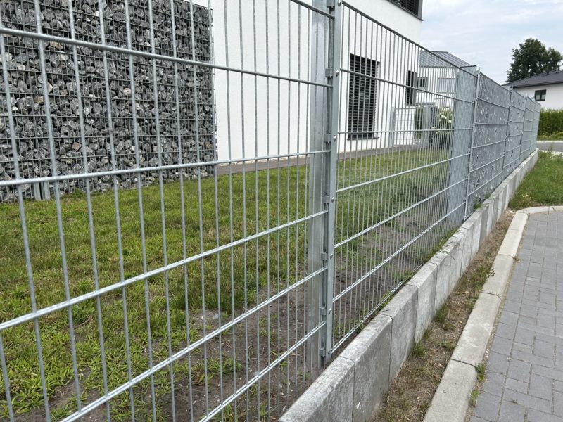 Eine feuerverzinkte Zaun-Gabionen-Kombination Eine feuerverzinkte Zaun-Gabionen-Kombination