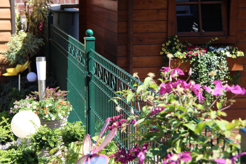 Moosgrün ist die natürlichste Gartenzaun-Farbe und fügt sich harmonisch in die Gartenbepflanzung ein. 